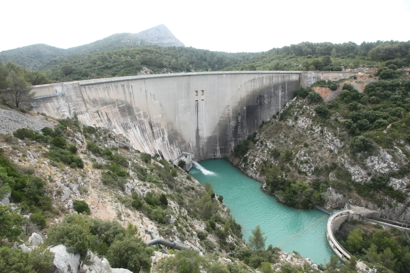 Le parement aval du barrage de Bimont, avec le pic de la Sainte-Victoire en arrière-plan